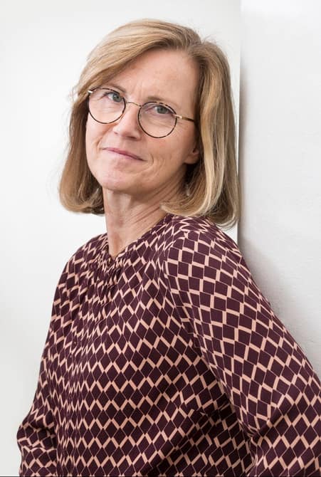 En bild av Lillemor Ivansson i en randig tröja lutad mot en vägg under fliken Om Beliva